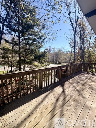 A deck with a railing and trees in the background.