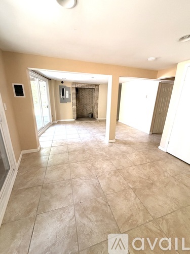 A spacious room with tiled flooring and a large open space.