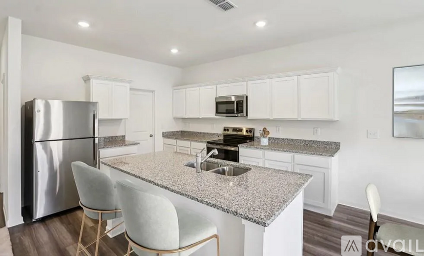 A kitchen with a granite countertop and white cabinets.