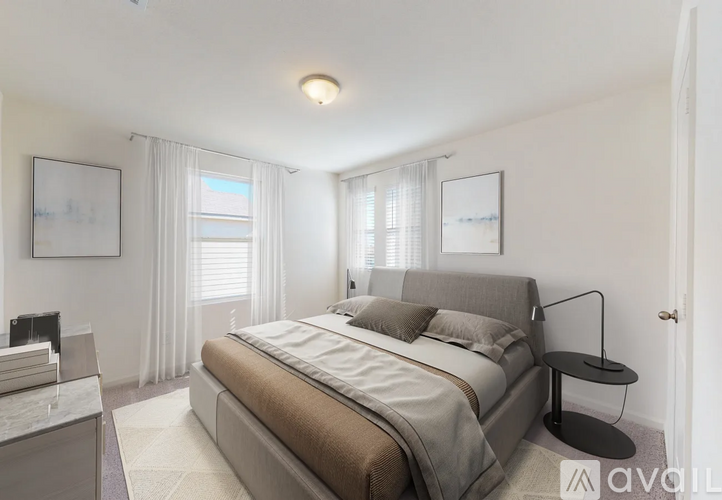 A bedroom with a large bed and a nightstand with a lamp.