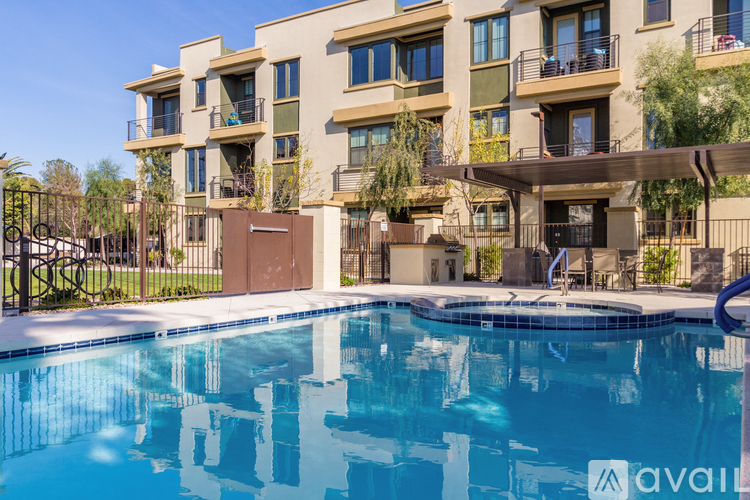 A large swimming pool in front of a multi-story apartment building.