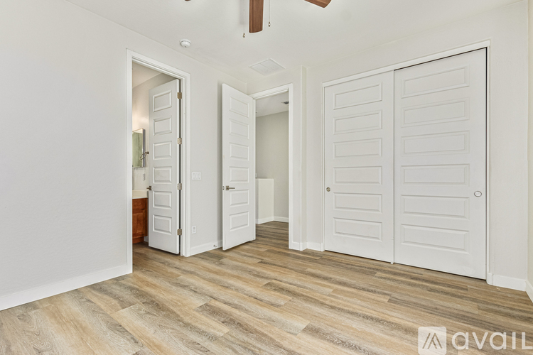 A room with white doors and wooden flooring.
