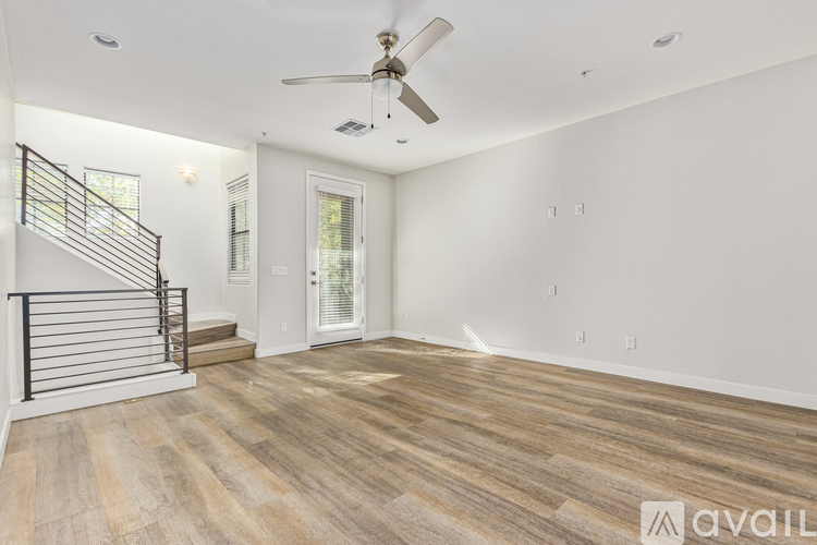 A spacious room with a wooden floor and a ceiling fan.
