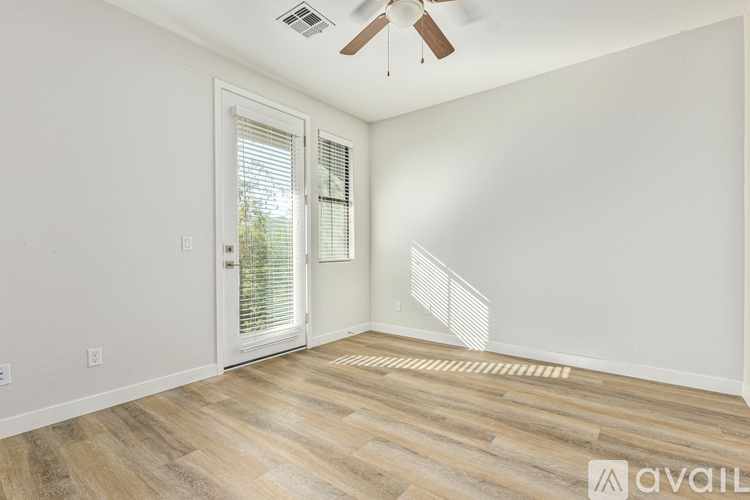 A room with a wooden floor and a ceiling fan.