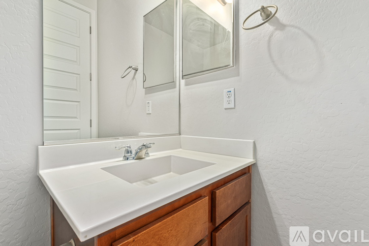 A white sink in a bathroom with a mirror above it.