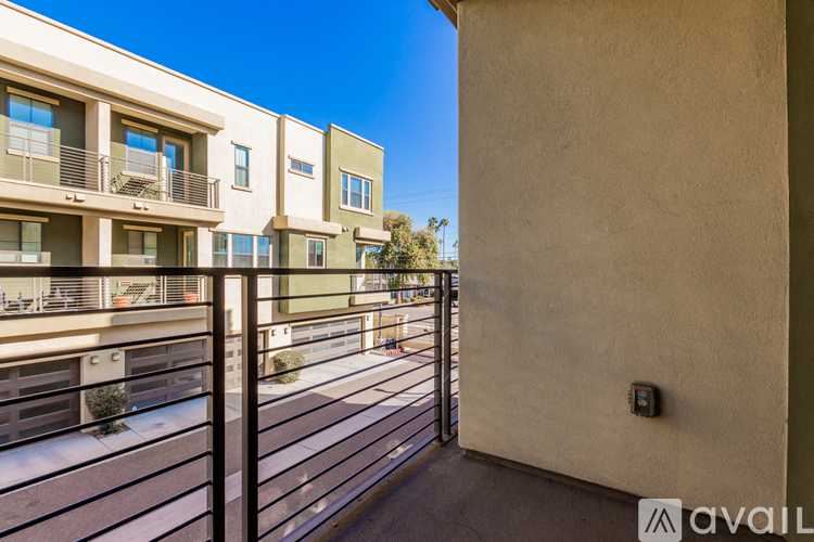 A row of modern townhouses with balconies and a metal railing.