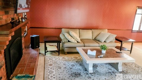 A living room with a couch, a coffee table, and a television.