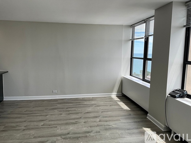 A room with a window and a wooden floor.