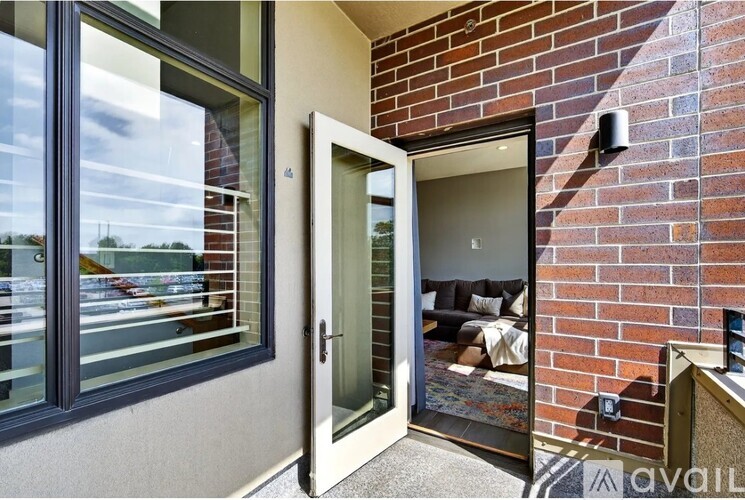 A modern house entrance with a glass door and a brick wall.