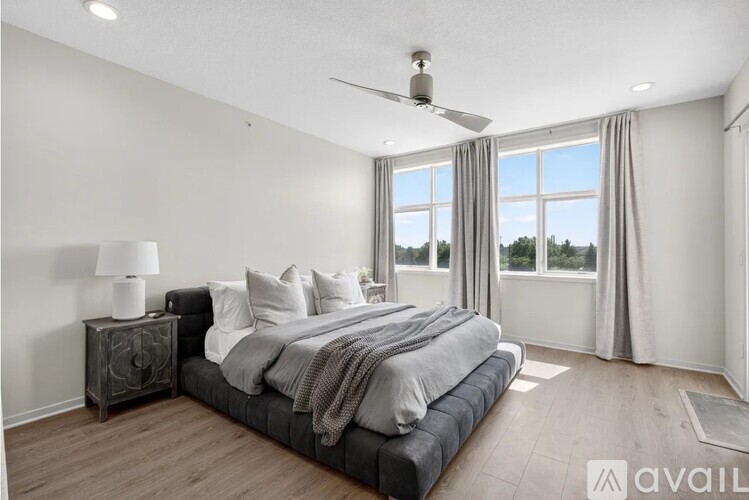 A bedroom with a large bed and a ceiling fan.