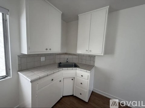 A kitchen with white cabinets and a tiled backsplash.