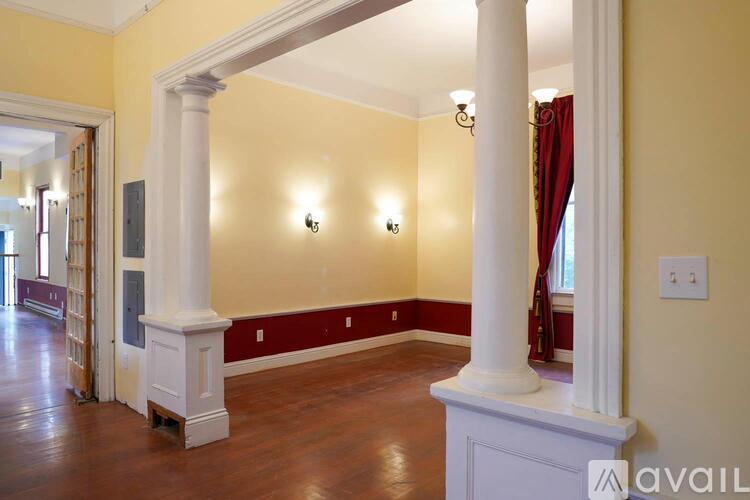A room with a yellow wall and a white column.