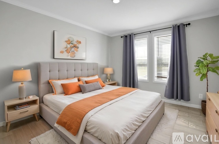 A bedroom with a large bed and a painting above it.