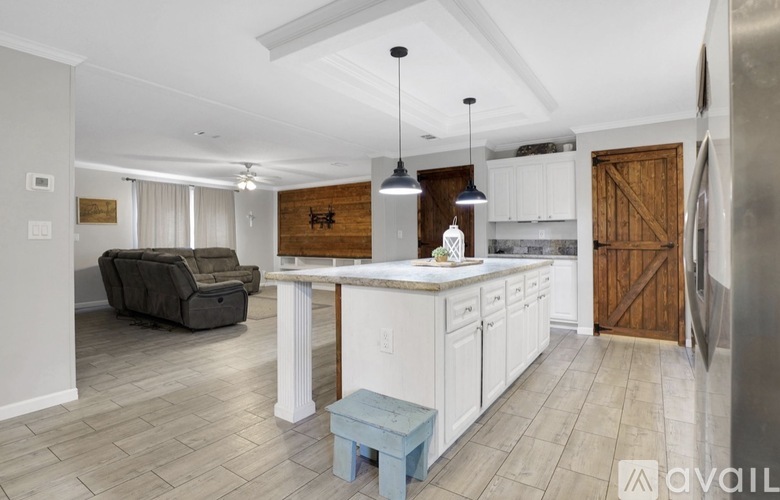 A kitchen with white cabinets and a wooden door.
