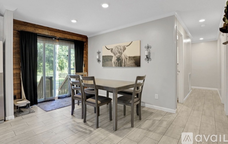 A dining room with a wooden table and chairs.