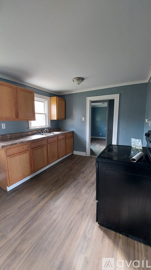 A kitchen with wooden cabinets and a black countertop.
