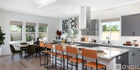 A kitchen with a table and chairs in front of a window.