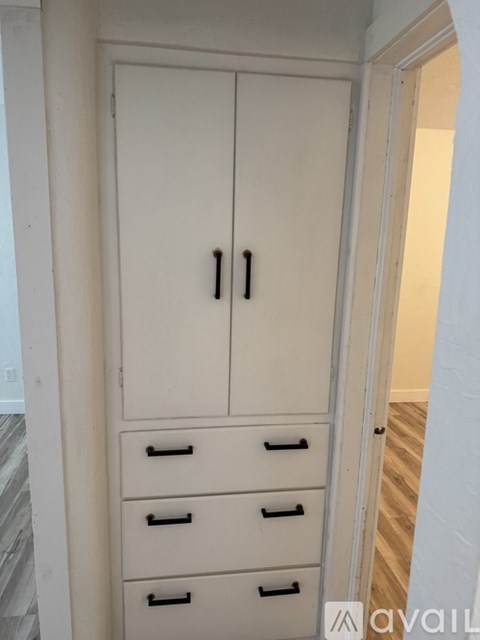 A white cabinet with two doors and three drawers is shown.