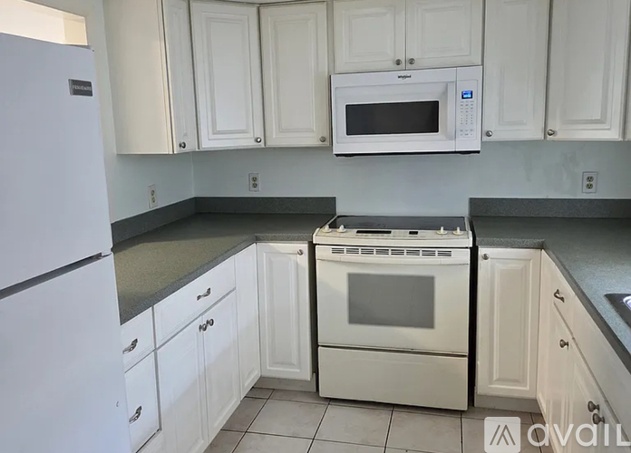 A kitchen with white cabinets and a white oven.