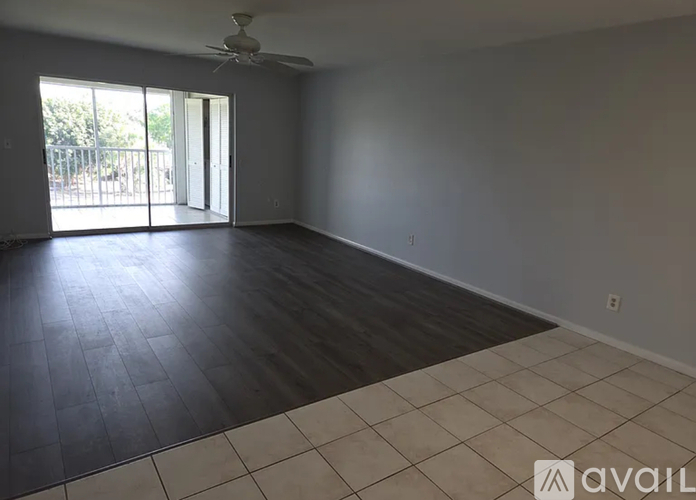 A spacious room with a ceiling fan and sliding glass doors.