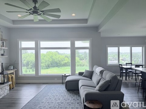 A living room with a grey couch and a ceiling fan.