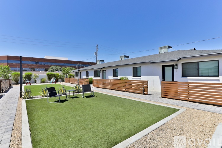 A modern house with a well-kept lawn and outdoor furniture.