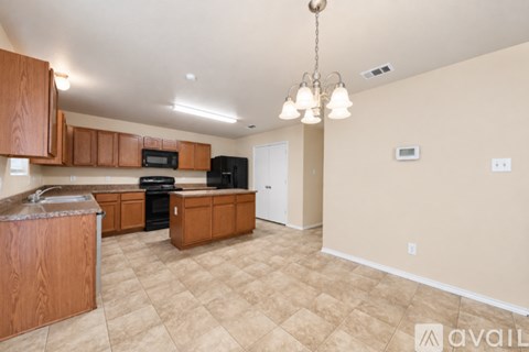 A kitchen with wooden cabinets and a black stove top oven.