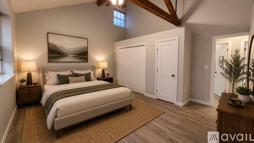 A bedroom with a large bed and a painting on the wall.