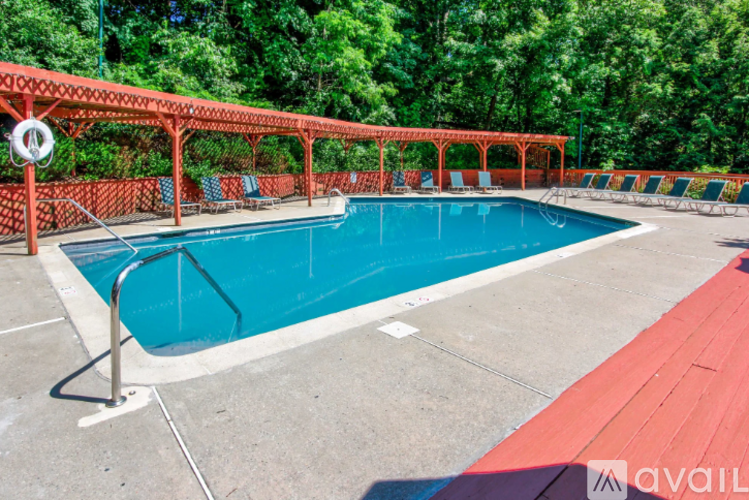 A pool surrounded by a red fence and trees.