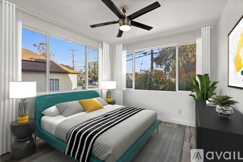 A bedroom with a large bed and a ceiling fan.