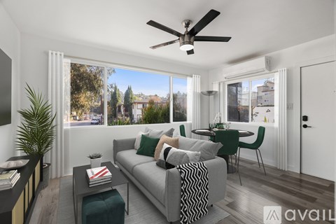 A living room with a grey sofa and a ceiling fan.
