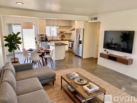 A living room with a grey couch and a coffee table with a bowl and a book on it.