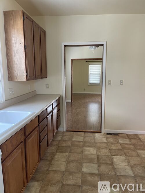A kitchen with brown cabinets and a tiled floor.