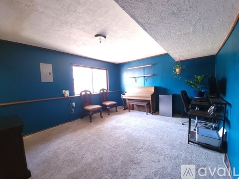 A living room with blue walls and a brown couch.