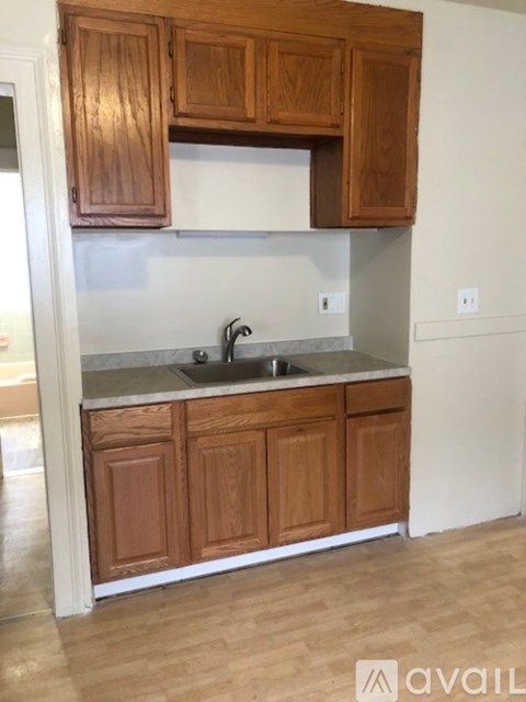 A kitchen with wooden cabinets and a marble countertop.