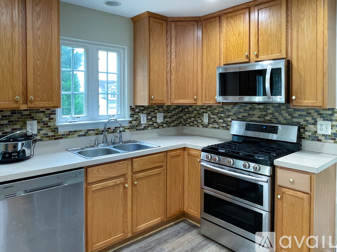 A kitchen with wooden cabinets and a black stove top oven.