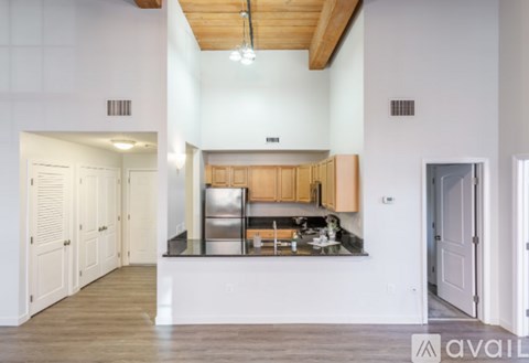 A kitchen with wooden cabinets and a stainless steel refrigerator.