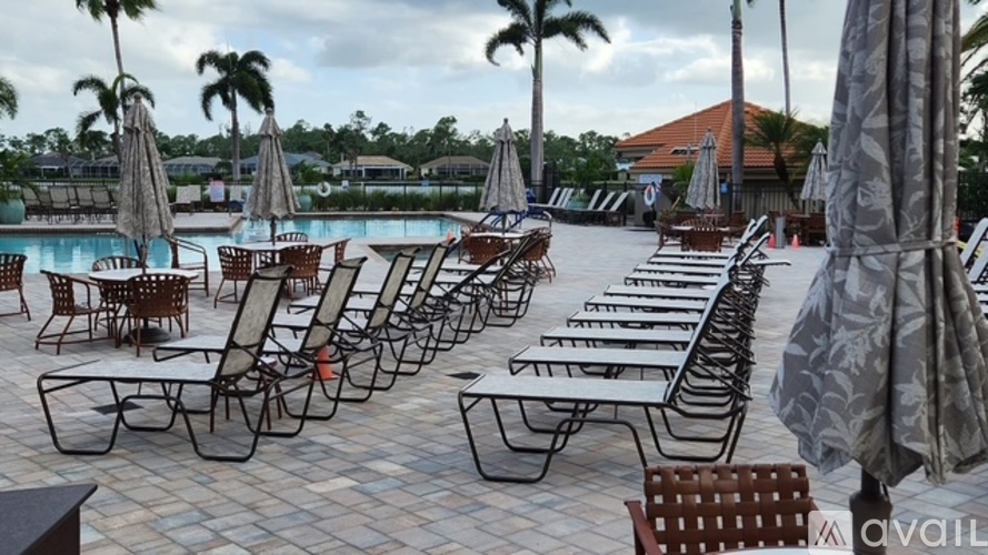 A poolside area with chairs and umbrellas.