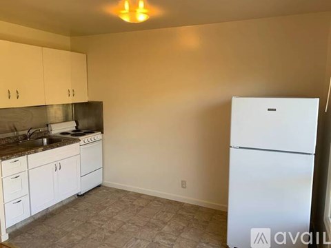 A kitchen with white cabinets and a white refrigerator.