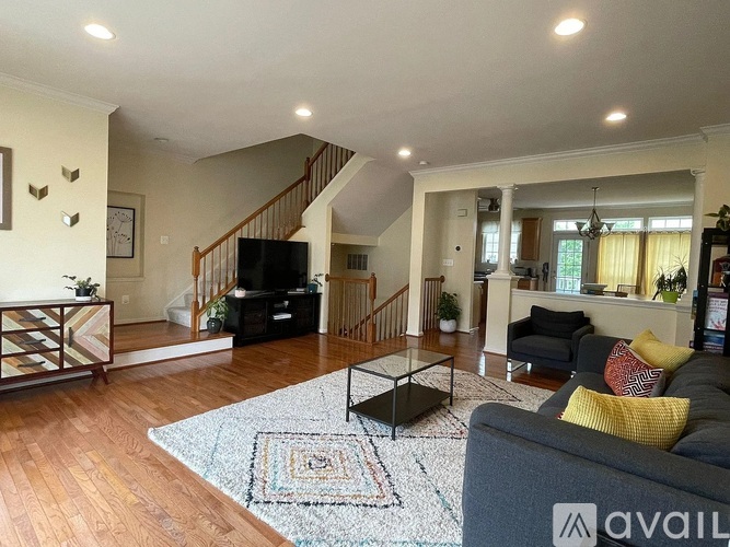 A living room with a grey couch and a rug.