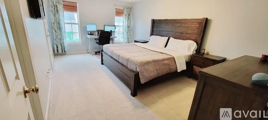 A bedroom with a large bed and a desk with a computer.
