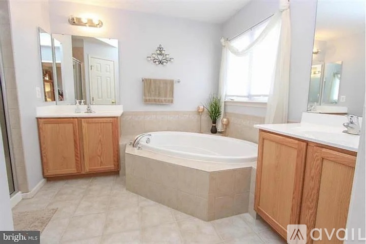 A spacious bathroom with a large tub and double sinks.