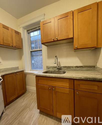 A kitchen with wooden cabinets and a marble countertop.