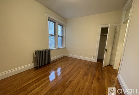 A room with wood flooring and a window with a closed door.