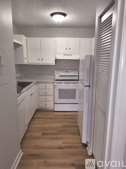 A kitchen with white cabinets and appliances.