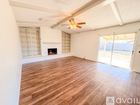 A room with wooden flooring and a fireplace.
