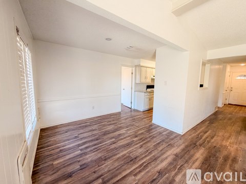 A room with wooden flooring and white walls.
