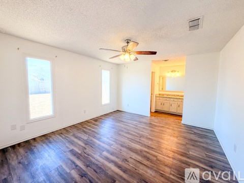 A room with wooden floors and a ceiling fan.
