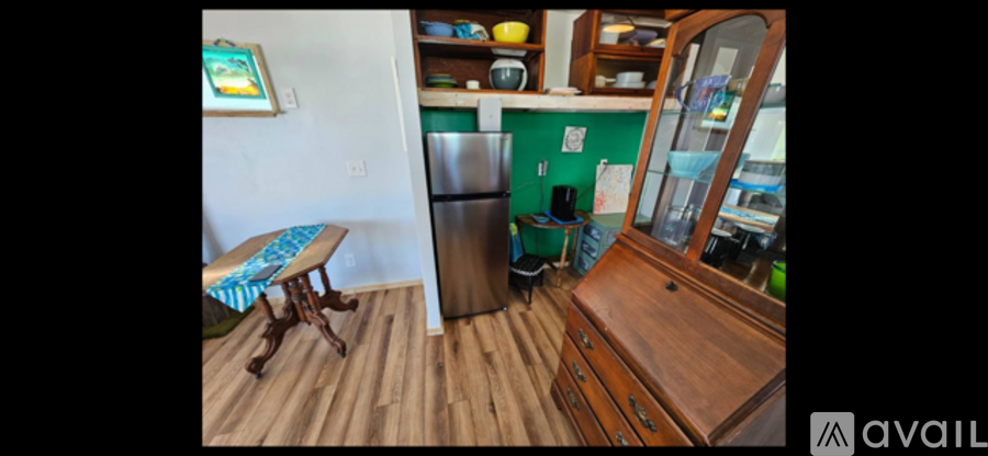 A kitchen with a wooden floor and a wooden table.