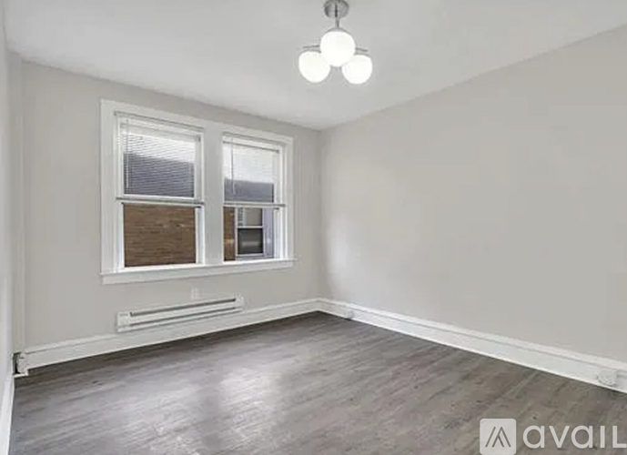 A room with a window and a wooden floor.